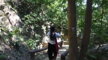 Tayland 'ın Chiang Mai kentindeki Doi Lo şehrindeki Mae Wang Ulusal Parkı' nın vahşi ormanlarında doğa yürüyüşü yaparak Pha Chor Kanyonu kayalıklarını gezen gezen gezginler.