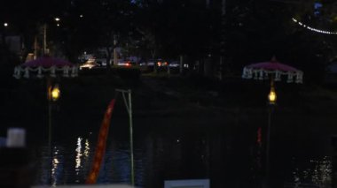 Dua bayrakları ya da Tung bayrağı nakışı geleneksel Kuzey Tayland tarzı gece vakti Tayland, Chiang Mai 'deki yerel restoranın Ping nehrinde asılı duruyor.