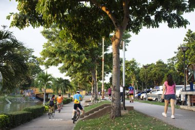 15 Eylül 2020 'de Tayland' ın Udon Thani kentindeki Nong Prajak halk bahçesi parkında gölet kenarında bisiklet sürerek yürüyüş yapan Asyalı Taylandlı ve yabancı gezginler.