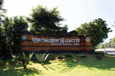 Tayland 'ın başkenti Chiang Mai' de 10 Kasım 2020 'de Doi Lo şehrindeki Pha Chor kanyon kayalıklarını gezen Taylandlılar için Mae Wang Ulusal Parkı girişi önündeki taş etiket bilgileri.