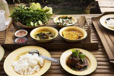 Thai local food southern style set and water drinks on retro vintage dinner lunch plate set for serve lunch meal to thai people and foreign traveler in dining terrace outdoor of restaurant in Thailand