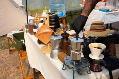 Thai men barista people use drip coffee maker or dripper made hot and iced coffee for sale beside irrigation canal at Bangbuathong city rural countryside on March 13, 2021 in Nonthaburi, Thailand