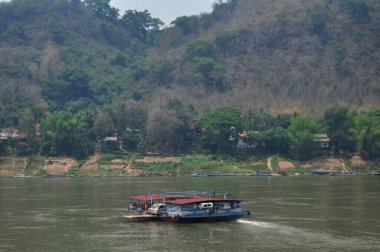 Yerel gemi feribotu liman iskelesinde duruyor. Yolcuları yollayın. Maenam Khong ya da mekong nehrinden geçenler 7 Nisan 2016 'da Louangphabang, Laos' taki adaya gitsinler.