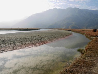 Phewa Tal ya da Fewa Freshwater Gölü nehri manzarası ve Pokhara, Nepal 'deki Gandaki Vadisi' ndeki Pokhara Vadisi köyü şehri Gandaki Pradesh 'te bulunan taşra ve himalaya dağlarının sulama rezervuarı.