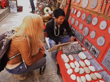 Nepal halkı, 2 Aralık 2017 'de Katmandu, Nepal' de Swayambhunath, Swayambu veya Swoyambhu 'da alışveriş yapan yabancı gezginler için Nepal tarzı hediyelik eşya satıyor.