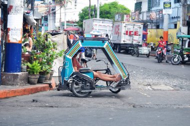 Filipinli ve yabancı yolcular için klasik antika trishaw trishaw bisikleti 17 Nisan 2015 tarihinde Manila, Filipinler 'de Intramuros Meydanı' nı ziyaret eder.