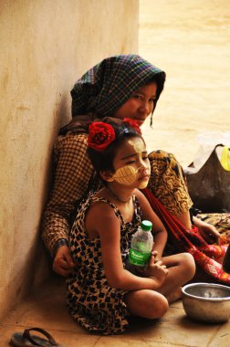 Birmanyalı anne ve oğul dilenci, 2 Şubat 2013 'te Man' da Shwezigon Pagoda Paya 'yı ziyaret eden burmalı insanlardan ve yabancı yolculardan para dileniyorlar.