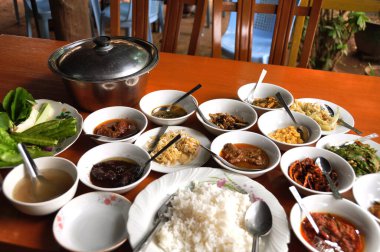 Birmanya yerel yemekleri, Burma halkı için öğle yemeği masasında servis ediliyor. Yabancı gezginler, Myanmar 'ın Mandalay kentindeki Bagan veya Pagan antik miras şehrindeki Nyaung U kasabasındaki yerel kafe restoranında içki içiyorlar.