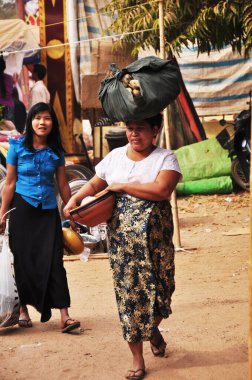 Birmanyalı ve yabancı gezginler 3 Şubat 2013 'te Mandalay, Myanmar veya Burma' da Bagan ya da Pagan 'daki sokak pazarı fuarından alışveriş malzemeleri ve hediyelik eşya satın alıyorlar.