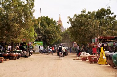 Birmanyalı ve yabancı gezginler 3 Şubat 2013 'te Mandalay, Myanmar veya Burma' da Bagan ya da Pagan 'daki sokak pazarı fuarından alışveriş malzemeleri ve hediyelik eşya satın alıyorlar.