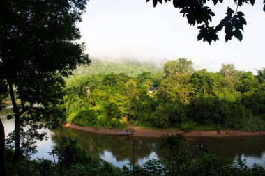 Tayland, Kanchanaburi 'deki Tham krasae mağarasını ziyaret eden Taylandlılar ve Taylandlılar için Sai Yok Şelaleleri Ulusal Orman Parkı' ndaki manzara ağacı ve si sawat veya khwae kwai nehrine bakın.