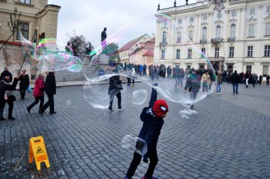 Çek halkı ve yabancı turistlerin Praha şehrinin eski şehir meydanına 11 Aralık 2016 'da Çek Cumhuriyeti' nin Prag kentinde ziyaret ettiklerini göstermek için kırılmaz dev kabarcıklar oynayan Çek halkı