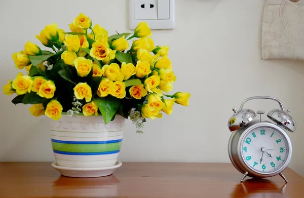 Relógio de alarme e vaso de flores — Fotografia de Stock