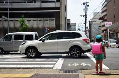 Çapraz yolu üzerinden bekleyen çocuk Japon kız