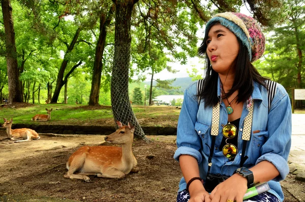 Femme thaïlandaise assise et prendre des photos avec des cerfs — Photo