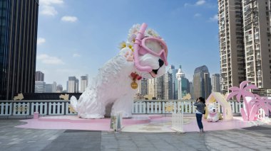Şirin köpek figürü ya da alışveriş merkezinin verandasının tepesine sevimli köpek heykeli oymak Çinli gezginler için gezgin Xiamen 'de 18 Ekim 2025' te Fujian, Çin 'de fotoğraf çek.