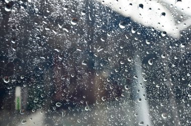 Cam plaka arka planlar üzerinde yağmur damlası