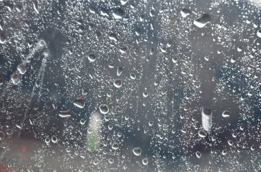 Cam plaka arka planlar üzerinde yağmur damlası