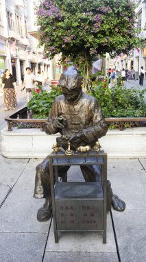 Çin 'in başkenti Fujian' da 17 Ekim 2025 'te Xiamen' e seyahat eden Çinliler için Zhongshan Yolu 'ndaki Pedestrian Caddesi' ndeki antik yaşam tarzının bronz heykelini oyan heykel.