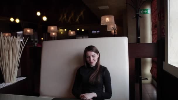 Chica bonita sonriendo en un café — Vídeos de Stock