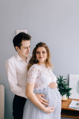 Windo 'nun önünde kocası olan hamile bir kadın.