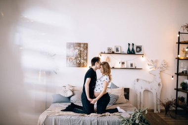 Adam hamile karısının karnına dokunuyor.