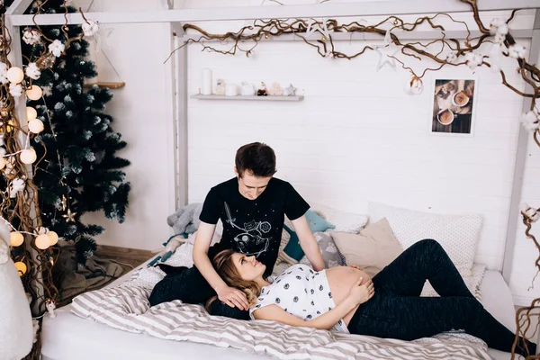 妊娠中の幸せな妻は夫とベッドに横たわっ — ストック写真