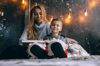 Anne ve küçük çocuk odada kitap okuyorlar.