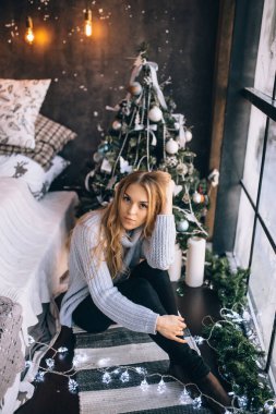 Pencerenin yanında güzel sarışın bir kızın portresi.