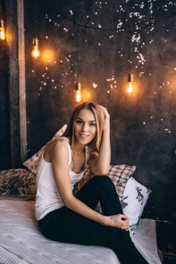 Yatakta güzel sarışın bir kadın var.