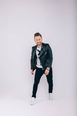 Siyah ceketli, gri arka plandaki adam.