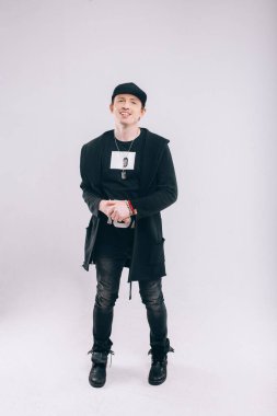 Beyzbol şapkalı, kendine güvenen genç bir manken. Beyaz arkaplan üzerinde izole edilmiş tüm vücut uzunluğu portresi.