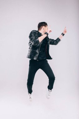 Genç adam ceketle stüdyoda eğleniyor.