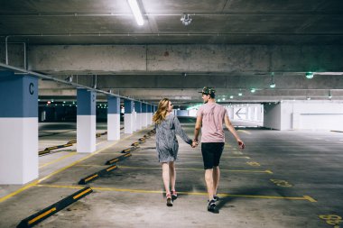 Sevimli mutlu çift eğlenir. Romantik fotoğraf. Otoparkta kucaklaşırlar.
