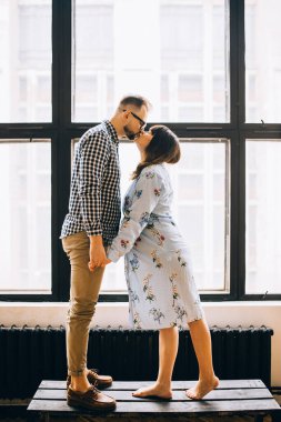 Birbirlerinin karşısında el ele tutuşan genç bir çift.