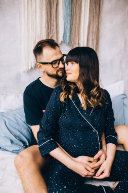 Yatakta bebek bekleyen genç bir çift.