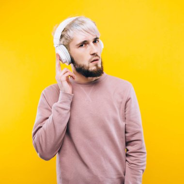 Sarı arka planda duran gülümseyen genç adamın portresi