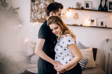 Adam hamile karısının karnına dokunuyor.