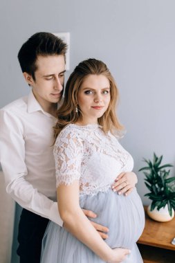 Pencerenin önünde kocası olan hamile bir kadın.