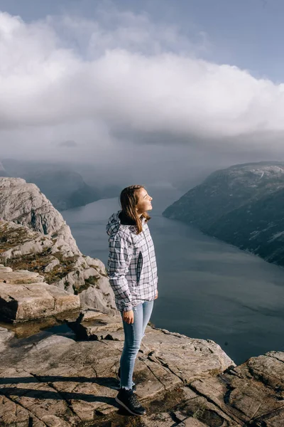 ノルウェーのプリケストロール山 Pulpit Rock の頂上に立つ可愛い女の子 ロイヤリティフリーのストック画像