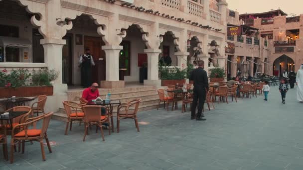 ドーハのSouq Waqif カタールのメインストリートのパンニングは コーヒーショップ 訪問者や地元の人々が座って歩いているのを示す日没で撮影しました — ストック動画