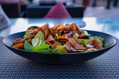 Şişko salatası (Lübnan salatası) resmi mavi bir tabakta kapat. Sebze ve çıtır tost ekmeği ile yapılır, sosu güzelce emer.. 