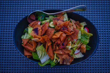 Şişko salatası (Lübnan salatası) resmi mavi bir tabakta kapat. Sebze ve çıtır tost ekmeği ile yapılır, sosu güzelce emer.. 