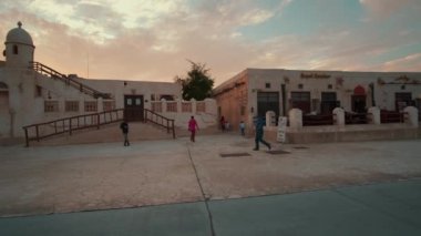 Souq Al Wakra, Souk Waqif Al Wakra, Katar 'daki Heritage Village ana caddede gün batımında çekilen çekimlerde yerli halk ve ziyaretçilerin yürüdüğü ve oturduğu ana caddeyi gösteriyor. 