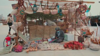 Doha Katar 'da düzenlenen geleneksel yemek festivalinin onuncu gününde geleneksel sepetler ve kilimler palmiye yapraklarından örüldü.