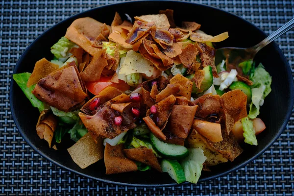 Şişko salatası (Lübnan salatası) resmi siyah bir tabakta kapat. Sebze ve çıtır tost ekmeği ile yapılır, sosu güzelce emer.. 