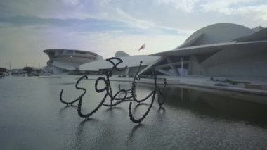 Doha Katar 'daki Ulusal Katar Müzesi günbatımına yakınlaşırken müzenin eşsiz mimarisini, çeşmesini ve gökyüzündeki bulutları gösteriyor. 