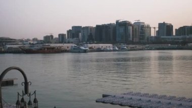 Doha ufuk çizgisi Box Park 'tan öğleden sonra yakınlaşıyor ve çekimde Arap Körfezi' ndeki dhov ve yatları ve arka plandaki Doha siluetini gösteriyor.