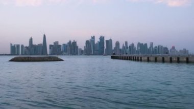 Doha ufuk çizgisi, Corniche gezinti alanından öğleden sonra çekilen fotoğrafta Arap körfezinde Katar bayrağı ve arka planda bulutlar görülüyor.