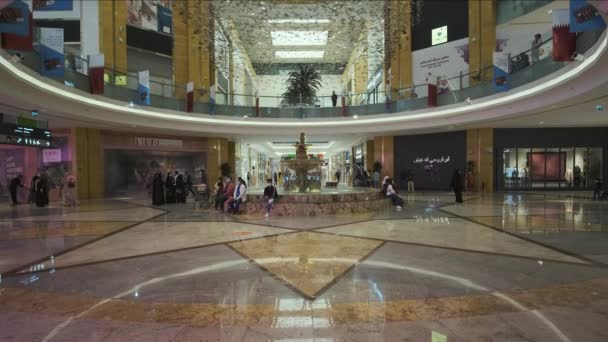 位于卡塔尔多哈的卡塔尔购物中心内的镜头放大 展示喷泉 卡塔尔国旗和游客欣赏购物中心的景象 — 图库视频影像